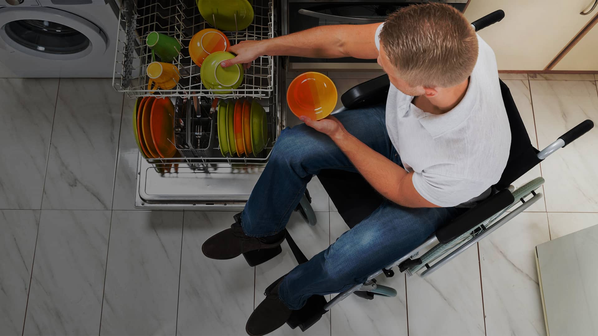 Man at dishwasher in kitchen - Independent Living Movement Ireland - DPCN | Disability Participation and Consultation Network