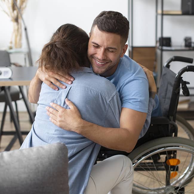 Man in wheelchair hugging woman - Mental Health Reform | DPCN - Disability Participation and Consultation Network