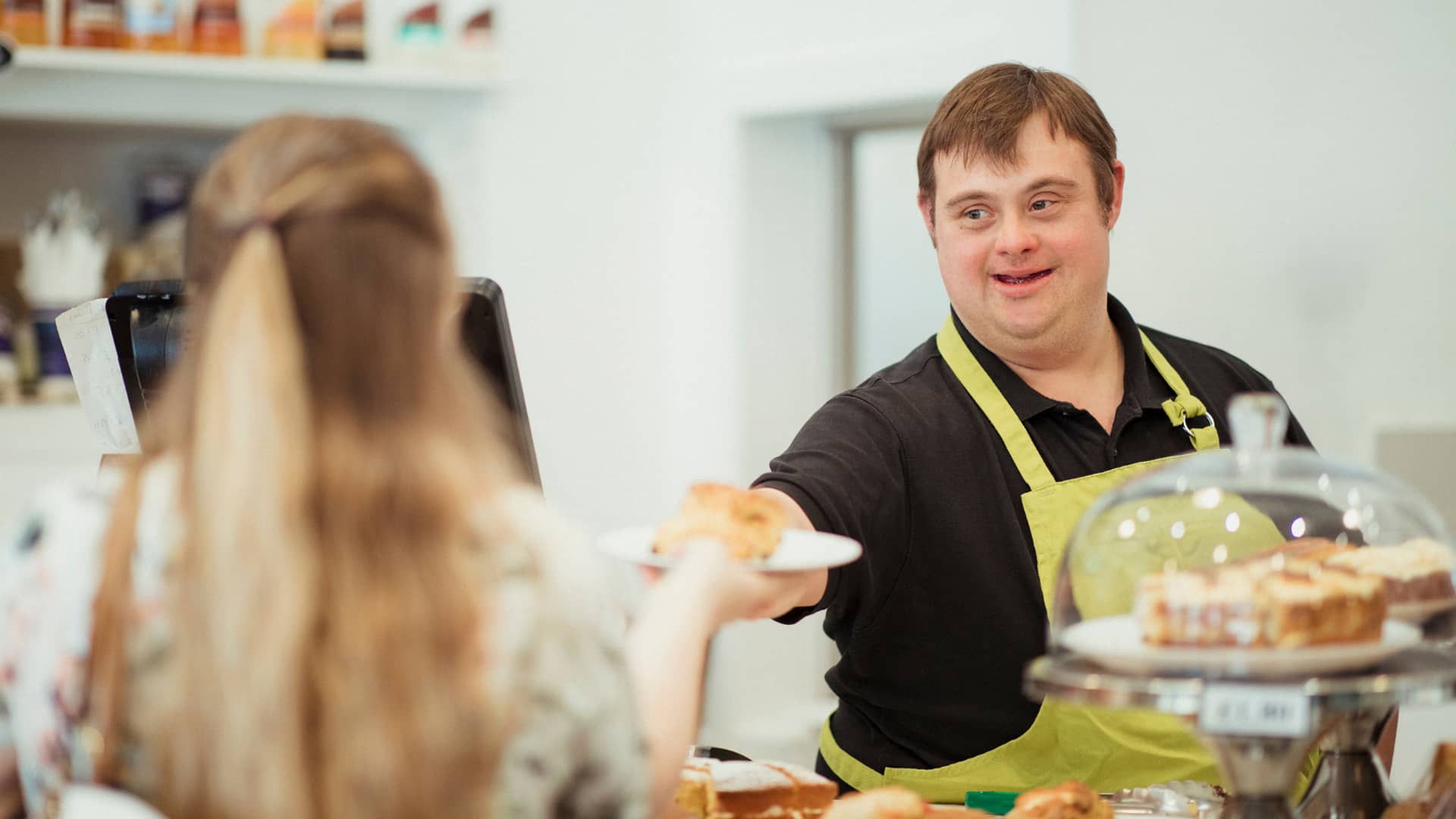 Man serving customer - Inclusion Ireland | DPCN - Disability Participation and Consultation Network