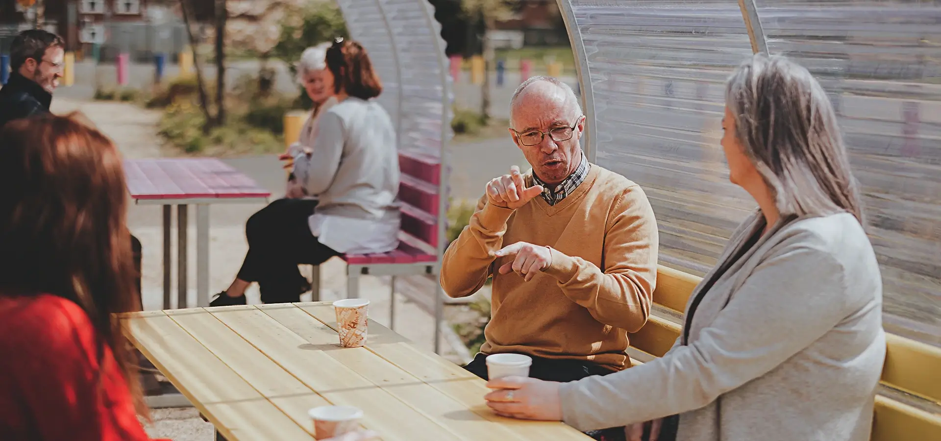 Man using sign language in company at an event - DPCN | Disability Participation and Consultation Network