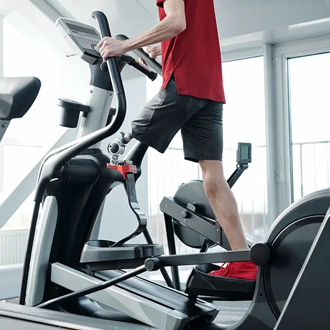 Man with a prosthetic leg on a cross trainer - Physical Impairment Ireland | DPCN - Disability Participation and Consultation Network